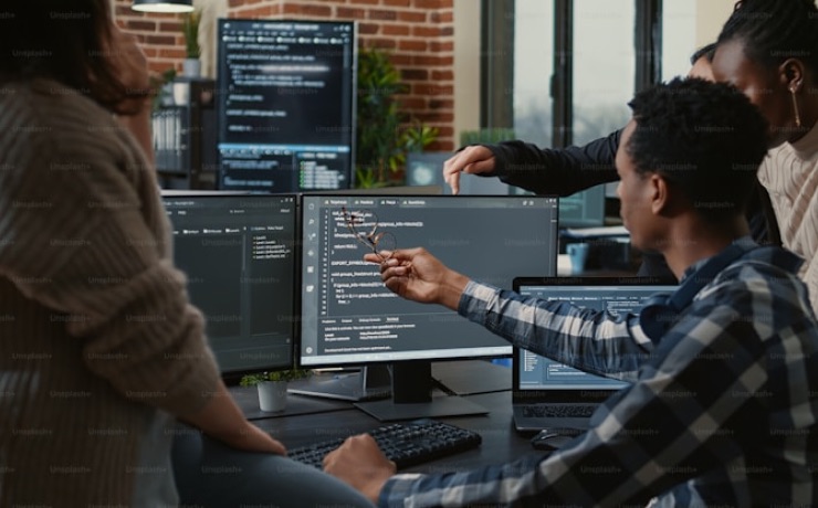 Developer's hands typing code on a dark-themed monitor with programming text visible