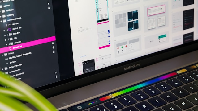 Monitor displaying wireframes and UI design mockups with a keyboard in the foreground